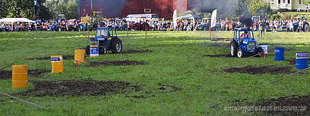 Två traktorer kör på banan