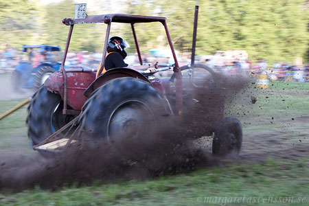 traktor med jord som skvätter runtom