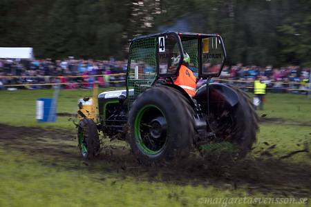 En traktor som kör så att leran sprutar.